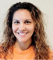 Professional headshot of smiling woman with curly hair wearing orange top against white background